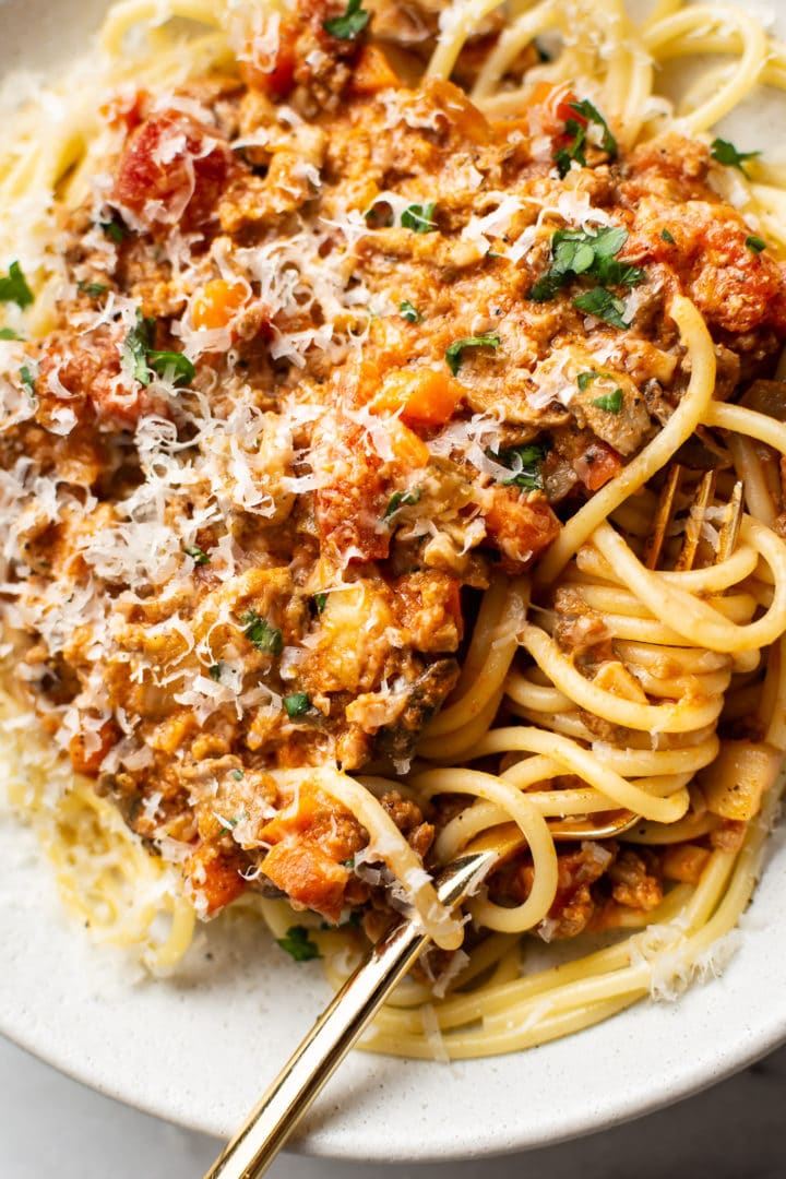 close-up of a shallow bowl with homemade spaghetti sauce over top of spaghetti