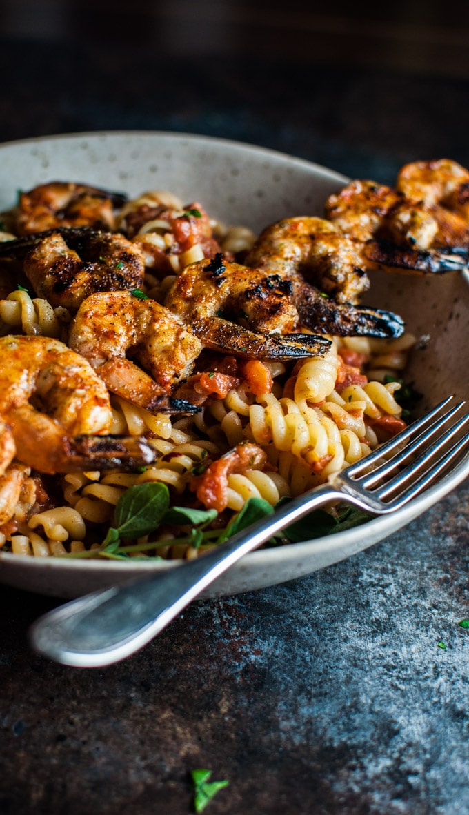 close-up of spicy grilled shrimp pasta in a bowl with a fork