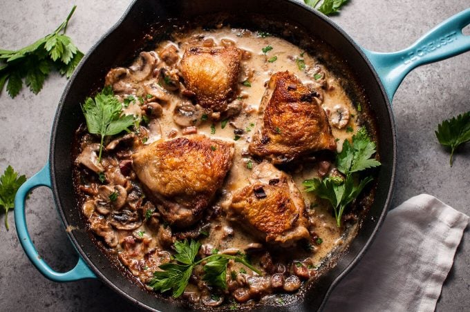 skillet of crispy pancetta and mushroom chicken in a bourbon cream sauce