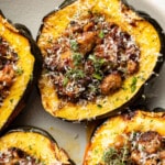 a plate with sausage stuffed acorn squash