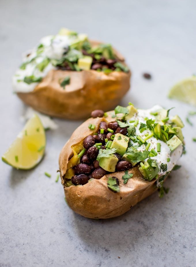 healthy stuffed sweet potatoes beside lime wedges