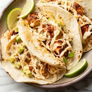 a plate with three blackened shrimp tacos