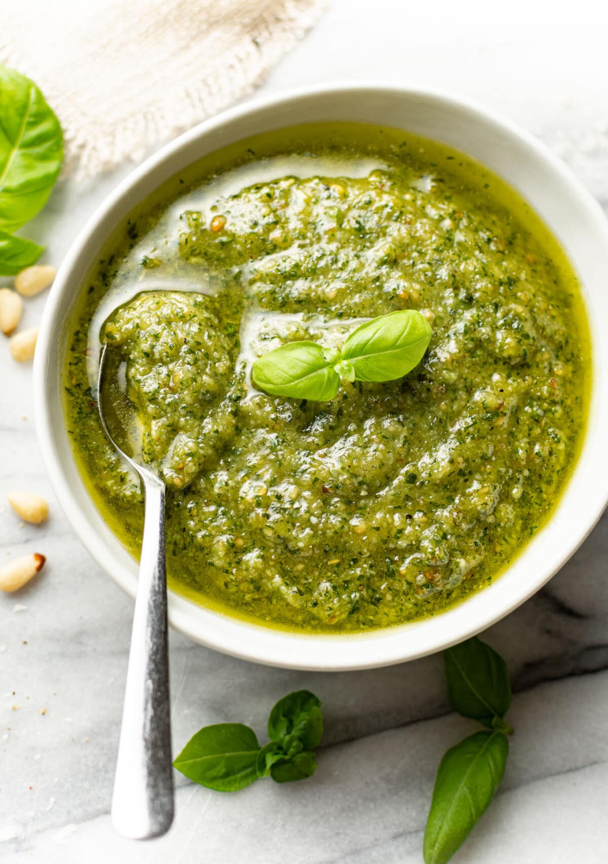 a bowl of homemade pesto sauce with a spoon