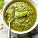 a bowl of homemade pesto sauce with a spoon