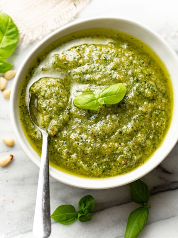 a bowl of homemade pesto sauce with a spoon