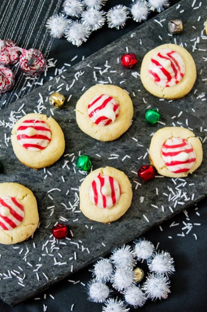 several candy cane Hershey kiss sugar cookies on a dark surface