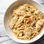 creamy garlic chicken pasta in a white bowl