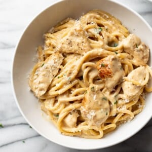 creamy garlic chicken pasta in a white bowl