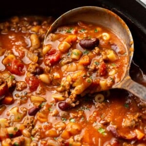 a ladle in a pot of pasta e fagioli soup