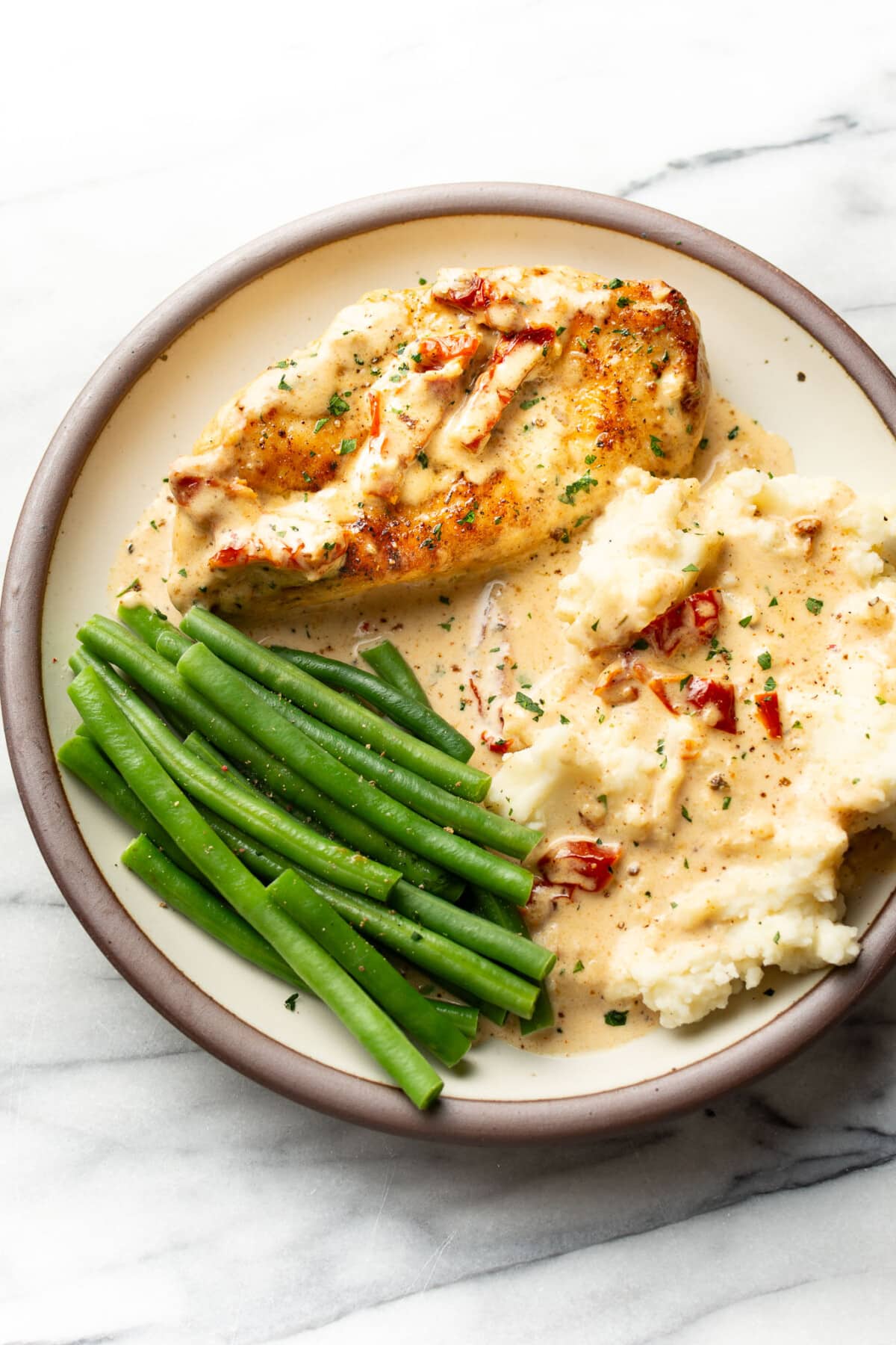 a plate with creamy cajun chicken, green beans, and mashed potatoes