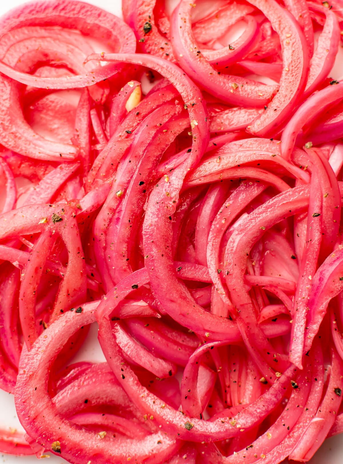 closeup of several slices of pickled red onions