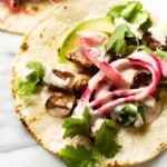 two steak tacos on a marble surface