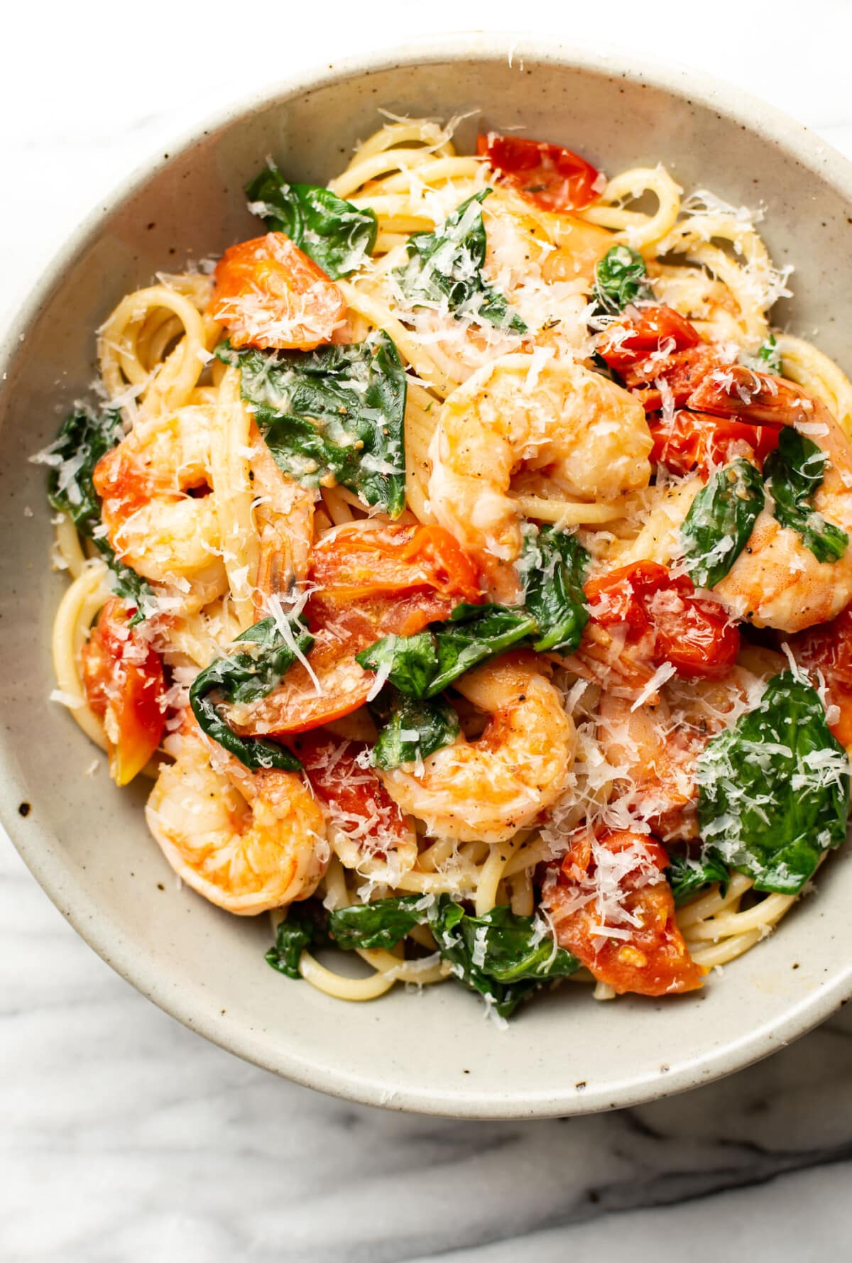 a bowl of tomato spinach shrimp pasta