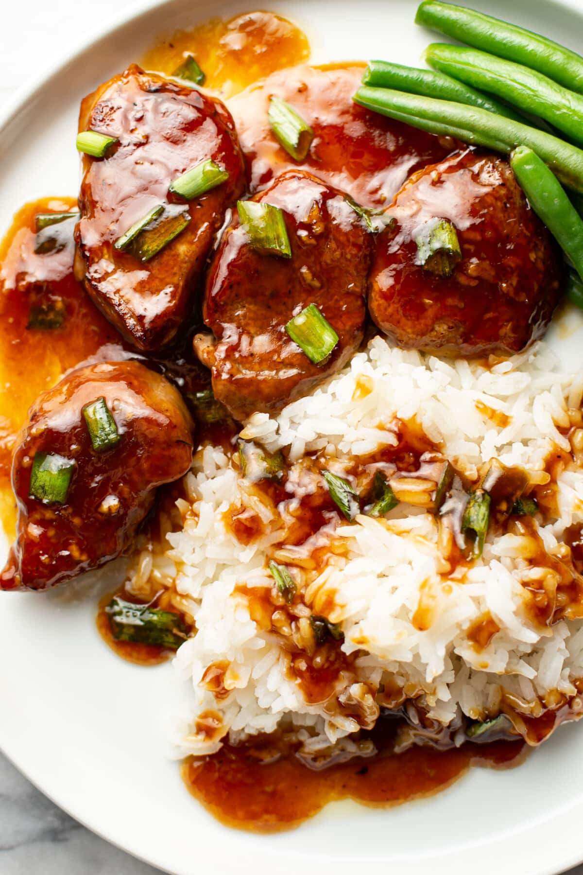 a plate with honey garlic pork tenderloin, rice, and green beans