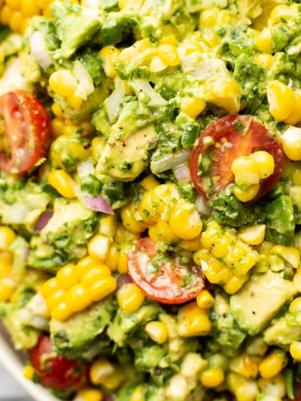 closeup of a bowl of corn salad with avocado