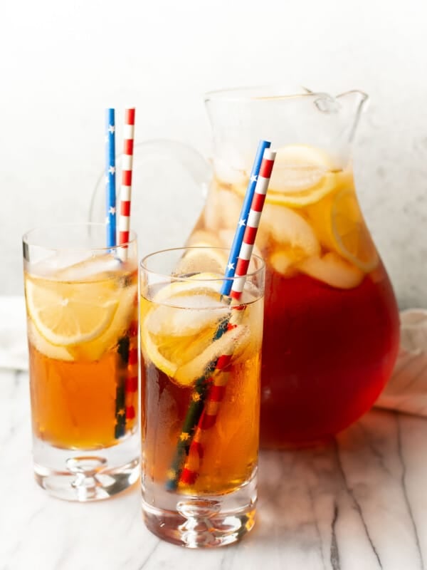 a pitcher of sweet tea with two glasses with straws