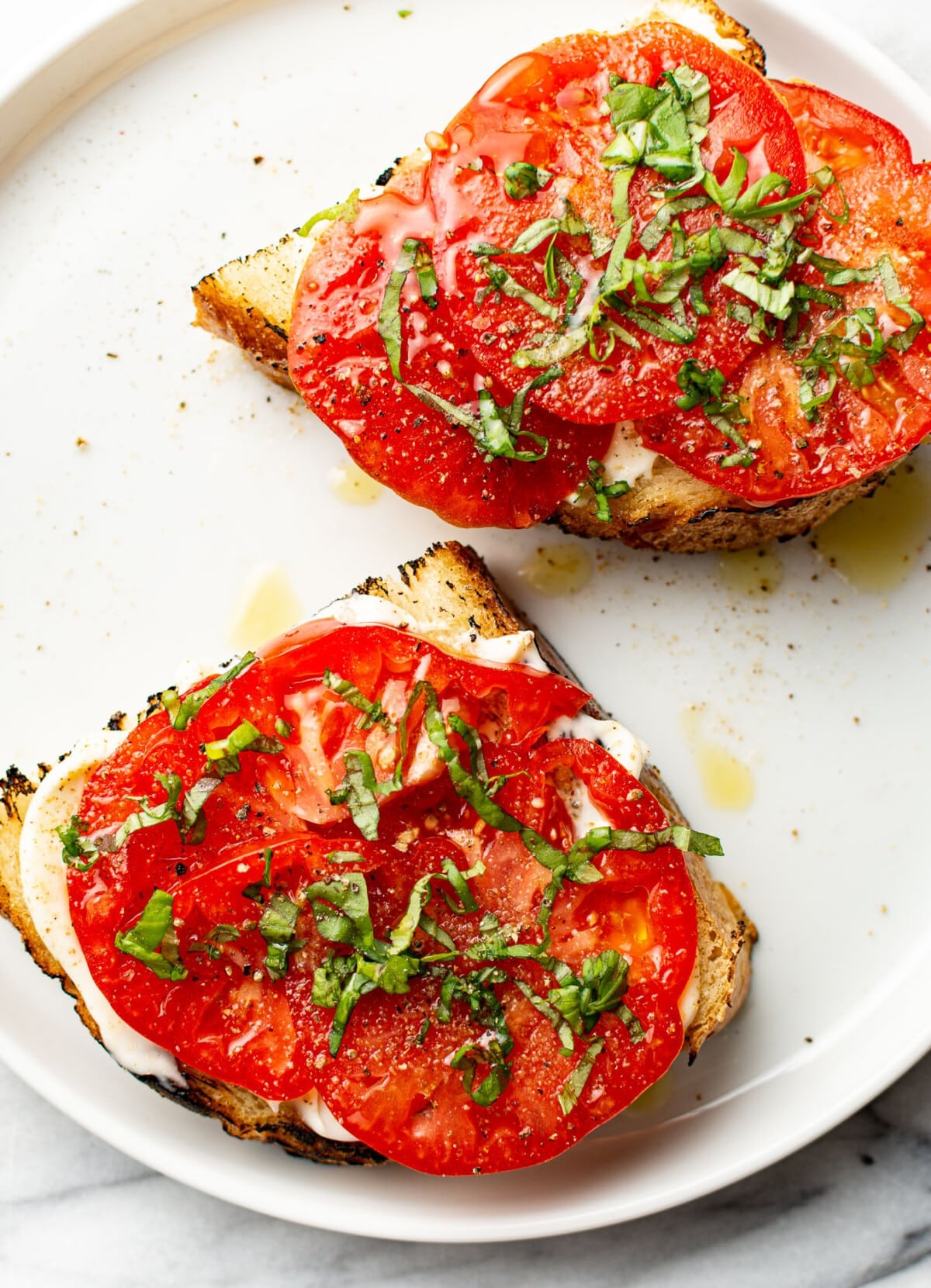 two summer tomato sandwiches on a plate