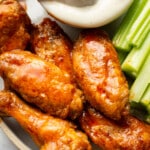 a plate of air fryer buffalo chicken wings with ranch dip and celery sticks