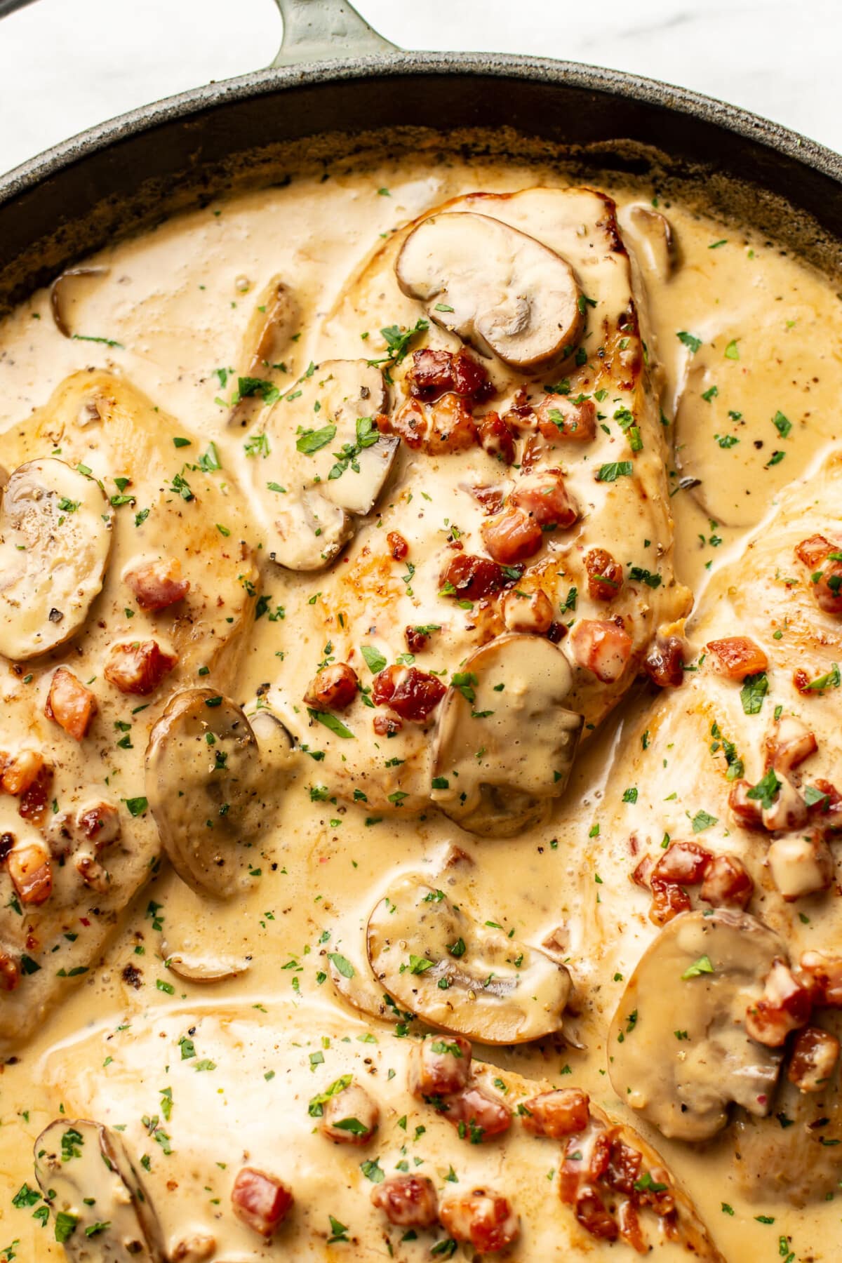 closeup of a skillet with creamy pancetta and mushroom chicken