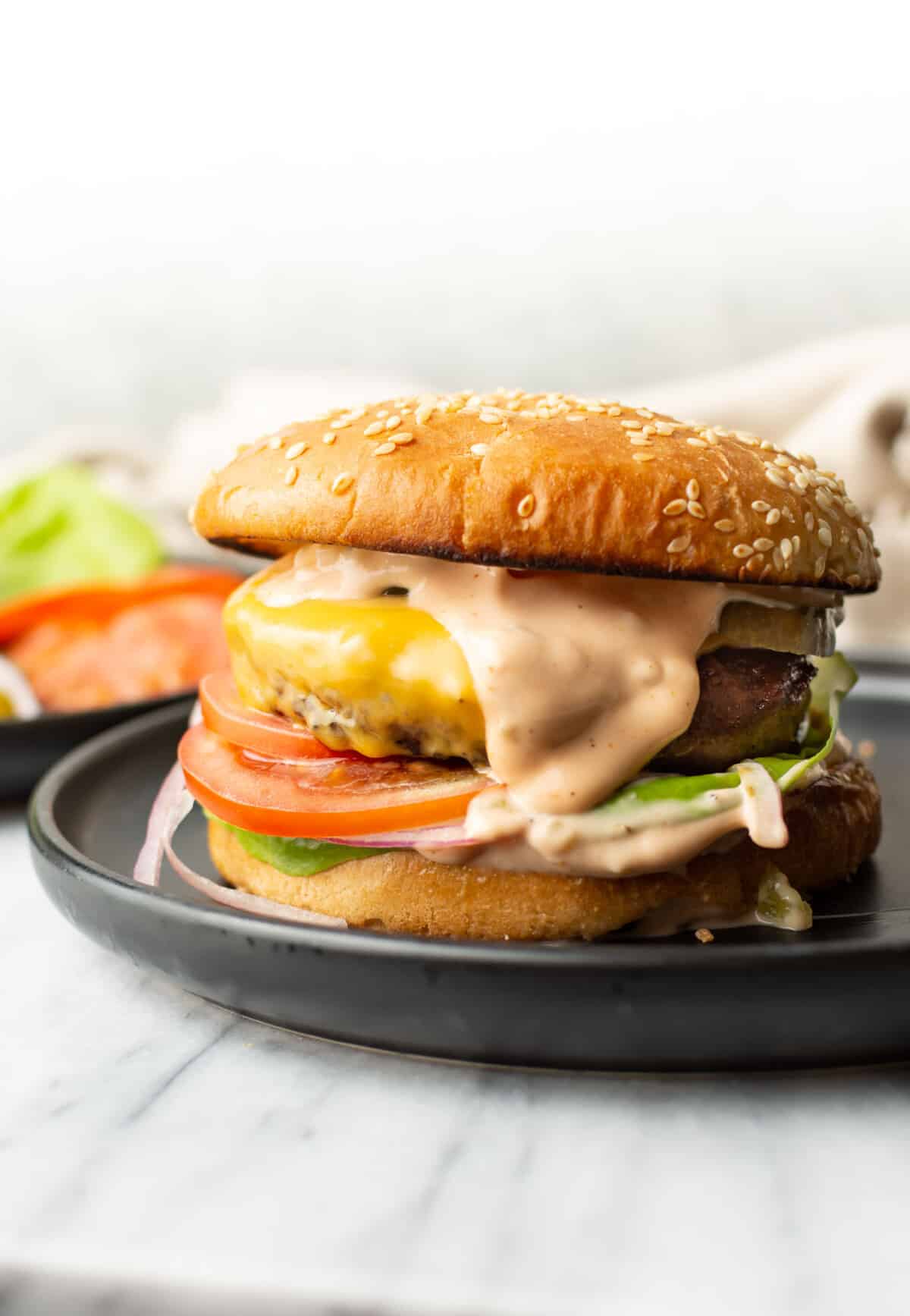 a burger on a plate with homemade burger sauce