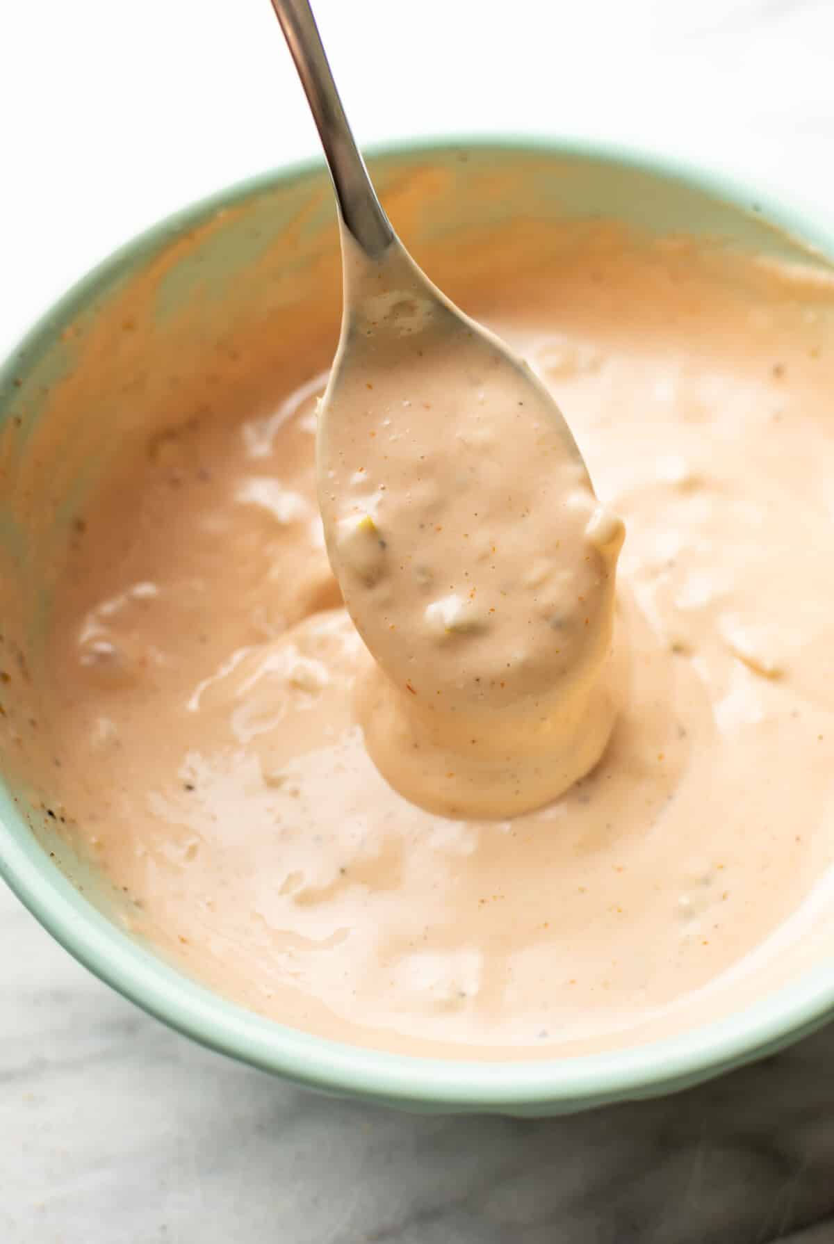 a prep bowl with homemade burger sauce and a spoon