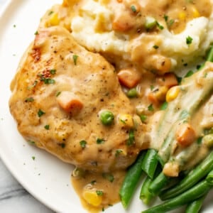 a plate with cream of chicken soup chicken breasts, green beans, and mashed potatoes