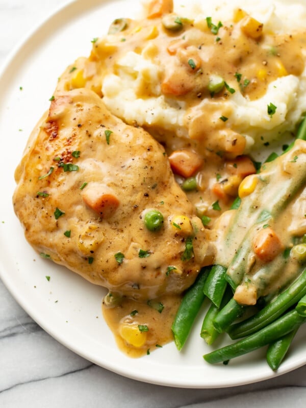 a plate with cream of chicken soup chicken breasts, green beans, and mashed potatoes