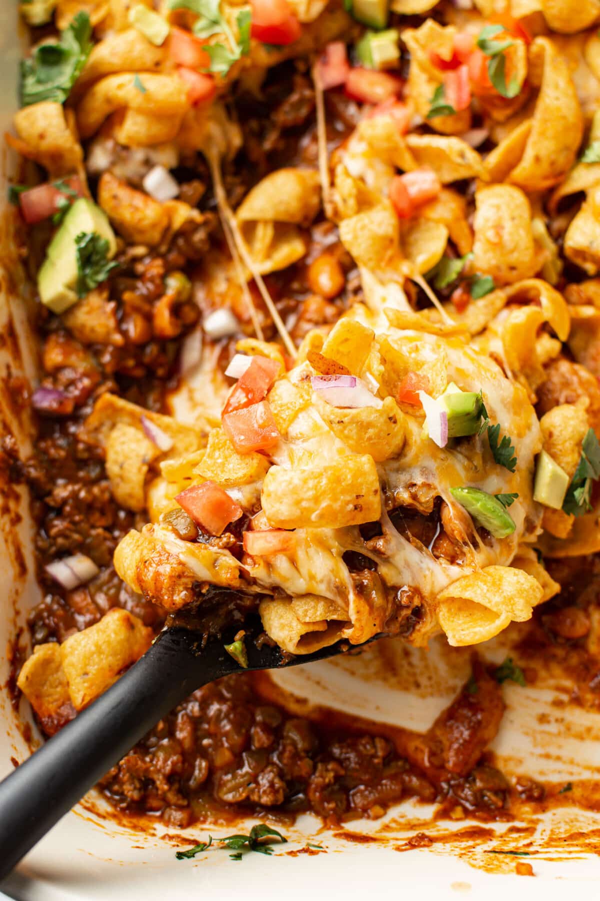 closeup of frito pie with a serving spoon