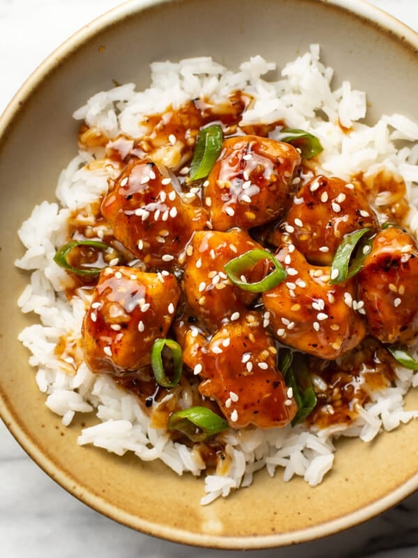 a bowl of sesame chicken with rice
