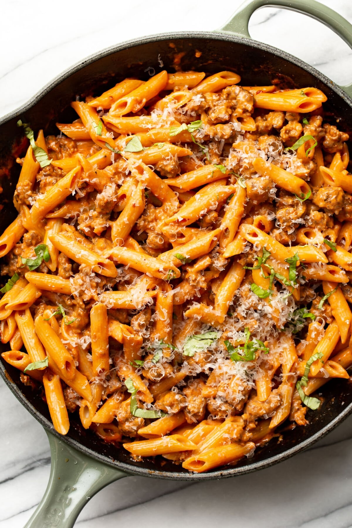 a skillet with penne alla vodka with italian sausage