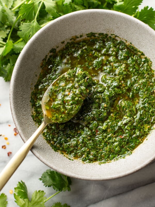 a bowl of homemade chimichurri sauce with a spoon