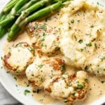 a plate with creamy white wine pork tenderloin, green beans, and mashed potatoes