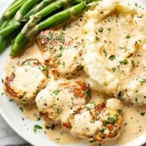 a plate with creamy white wine pork tenderloin, green beans, and mashed potatoes