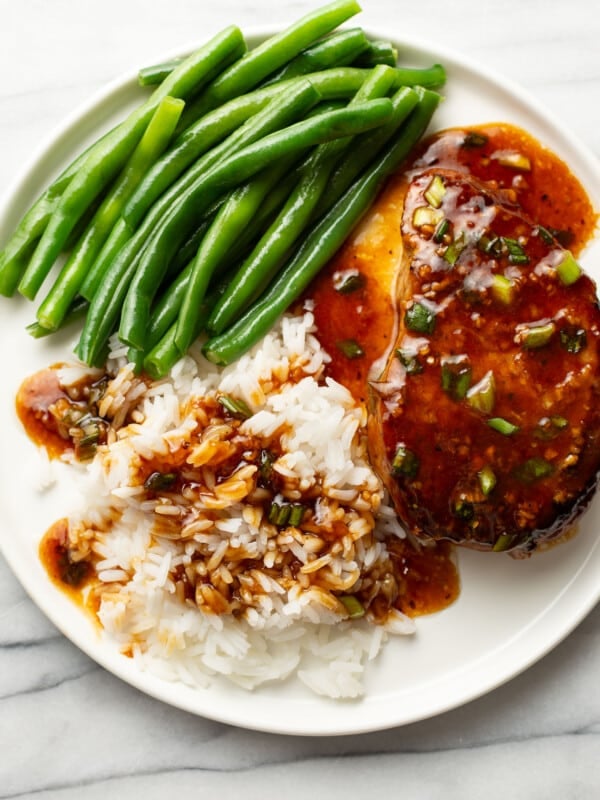 a plate with honey garlic pork chops, green beans, and rice