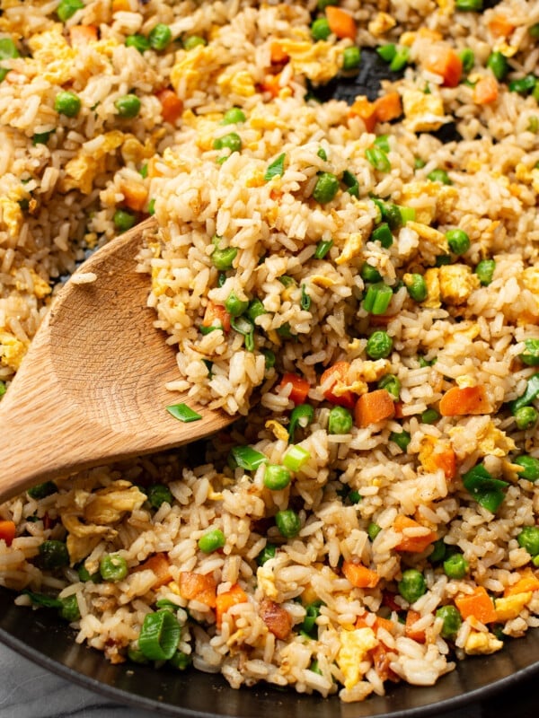 a skillet with fried rice and a wooden spoon