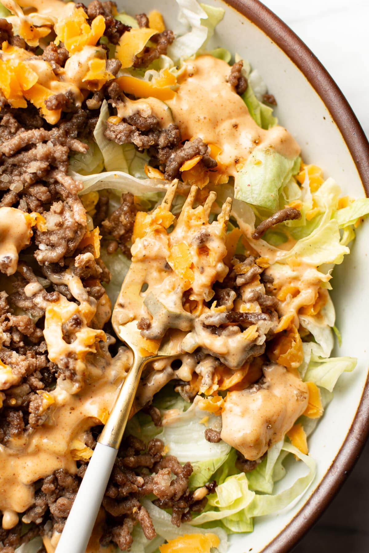 closeup of a bowl of big mac salad with a fork