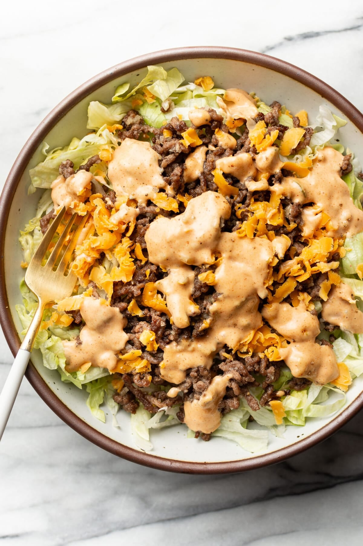 a bowl of big mac salad with a fork