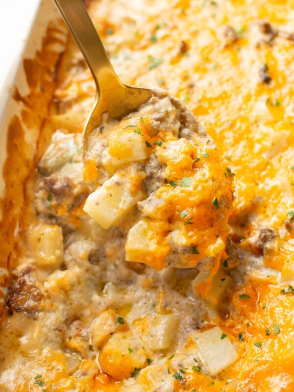 closeup of ground beef and potato casserole with a serving spoon