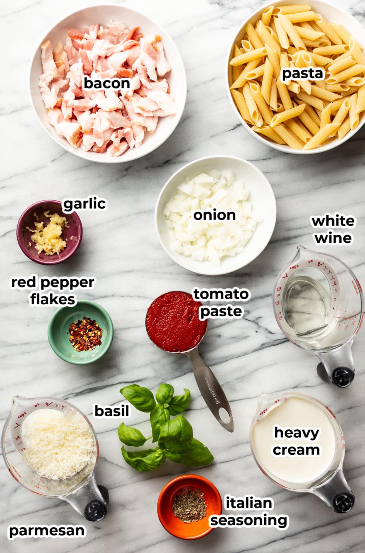 ingredients for spicy bacon tomato pasta in prep bowls