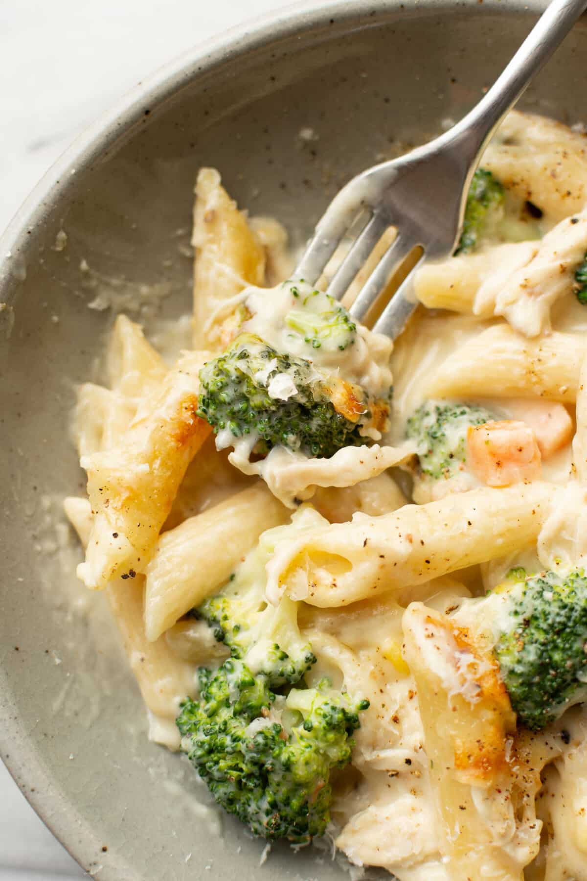 a bowl of chicken penne casserole with a fork