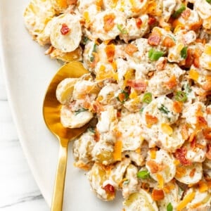 a plate with bacon ranch potato salad and a serving spoon