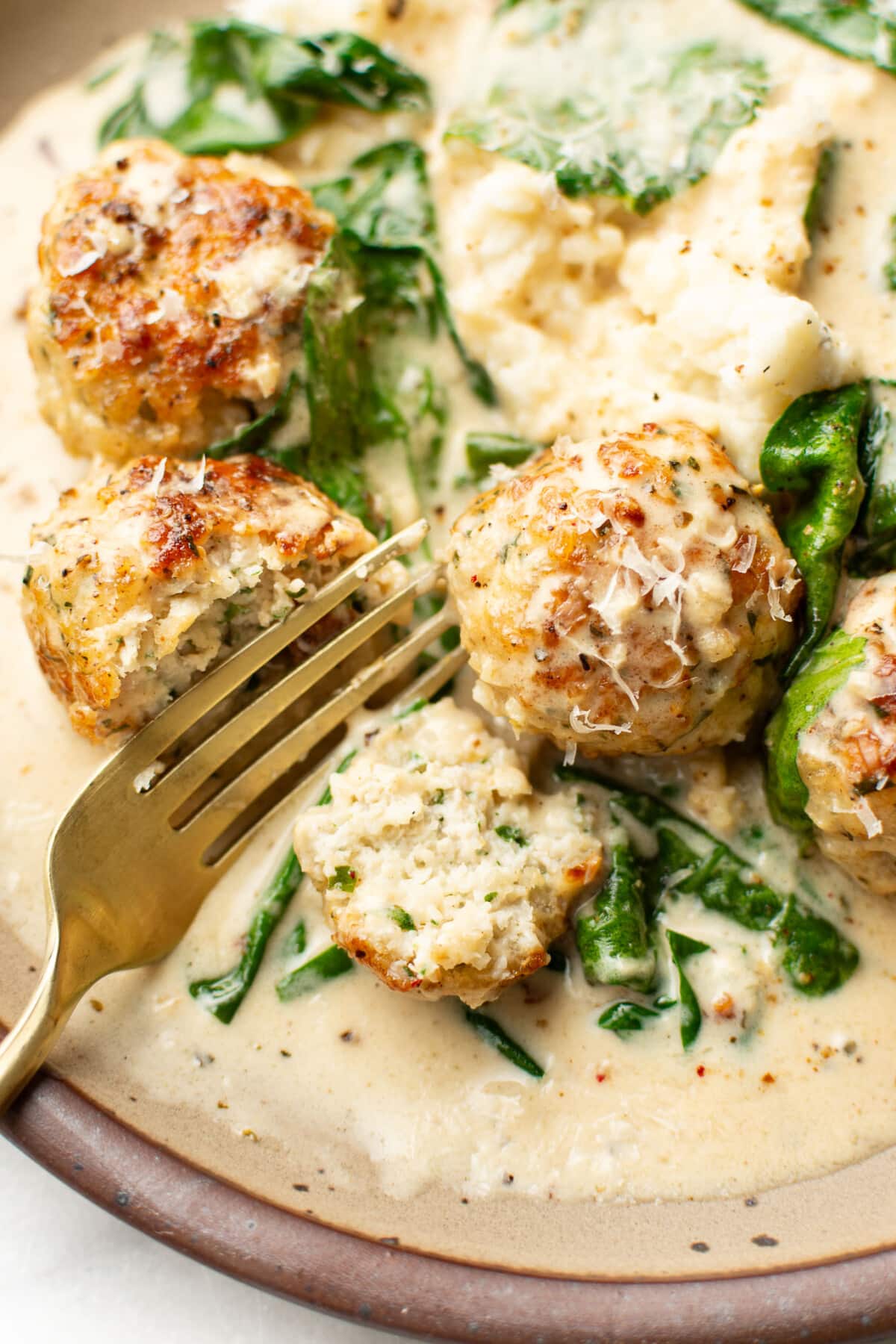 a plate with chicken florentine meatballs and a fork