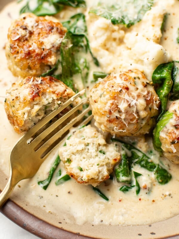 a plate with chicken florentine meatballs and a fork