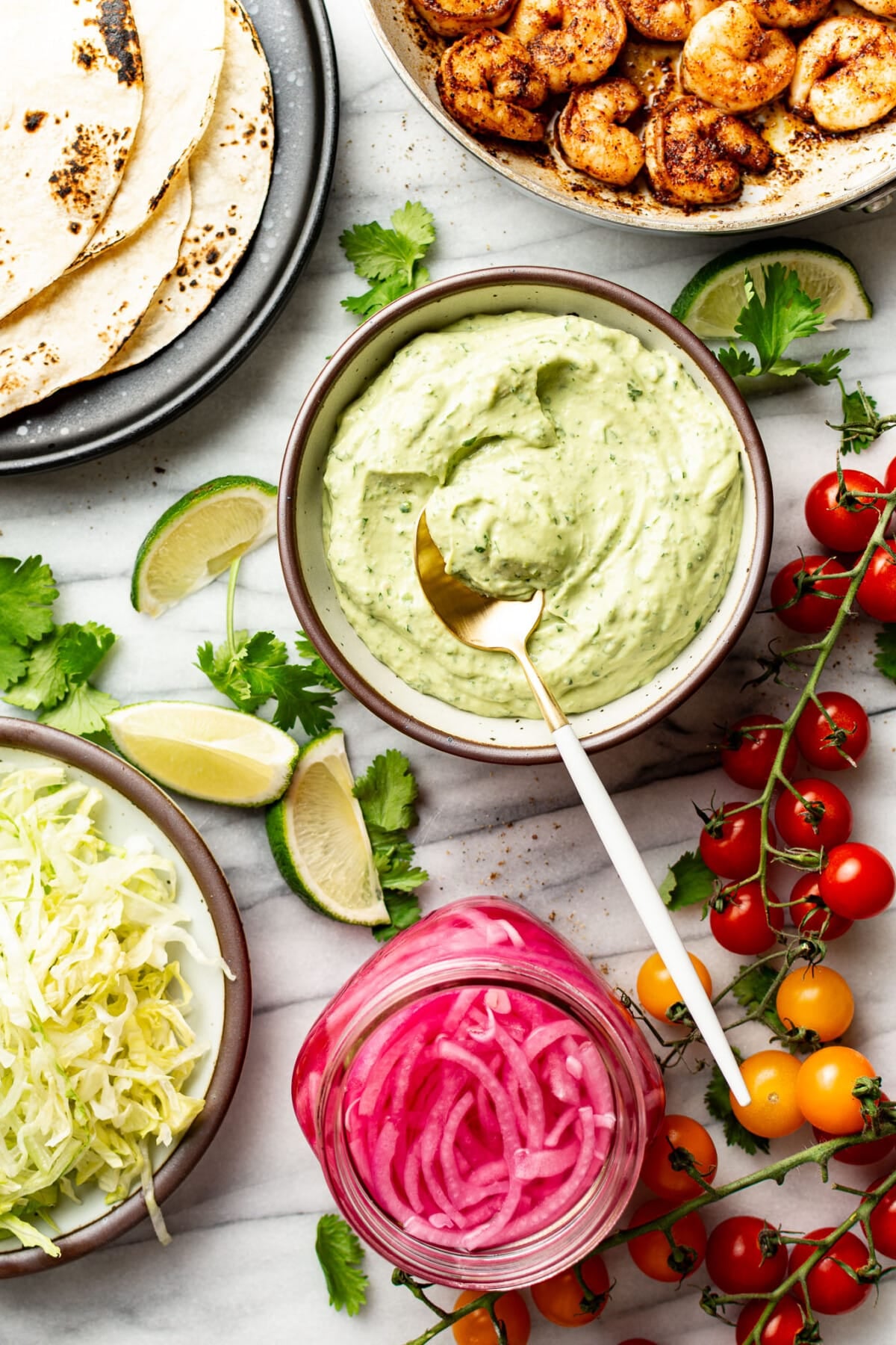 ingredients for tacos next to a bowl of creamy avocado sauce