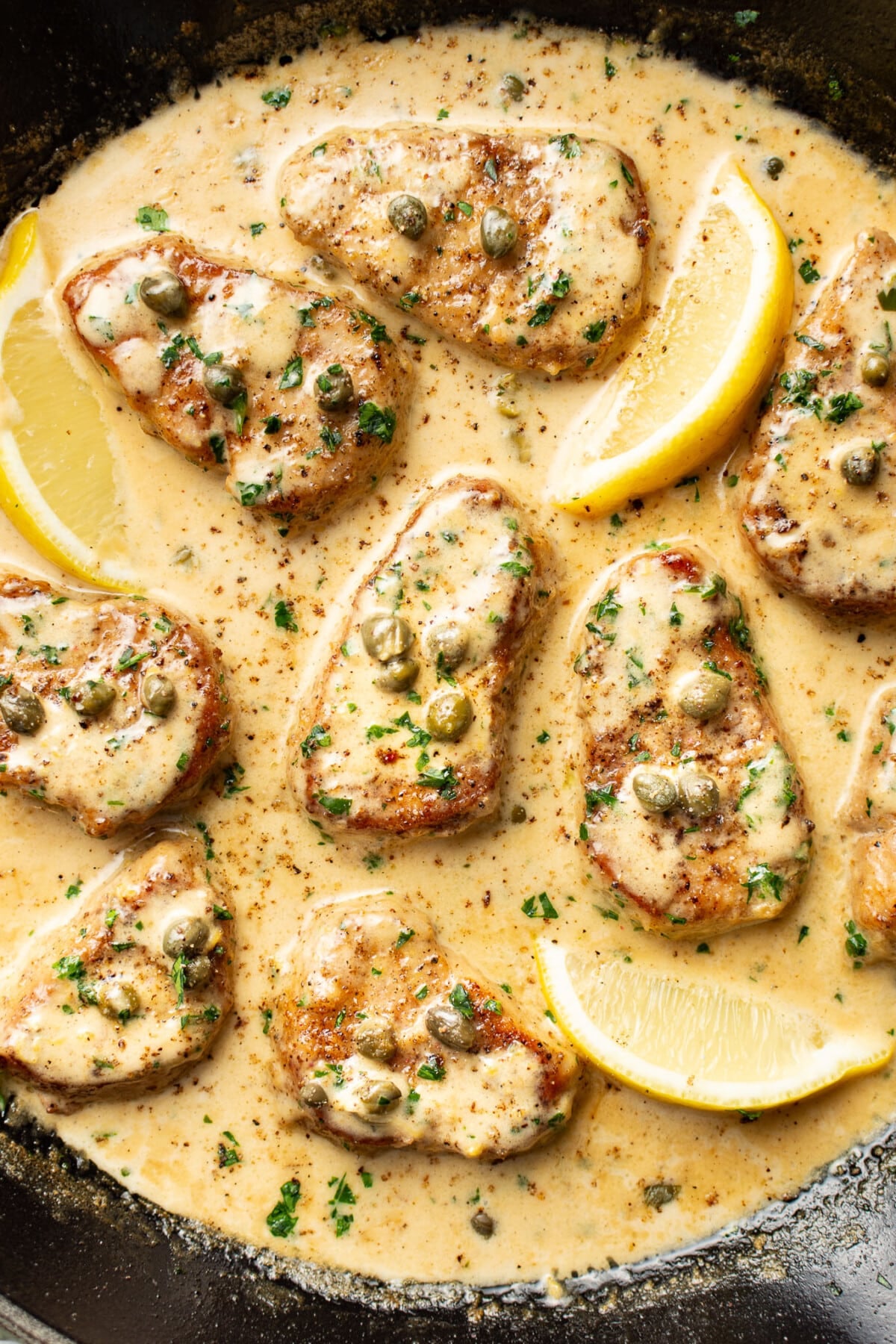 a skillet with pork tenderloin piccata