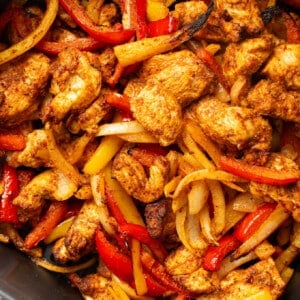 an air fryer basket with chicken fajitas