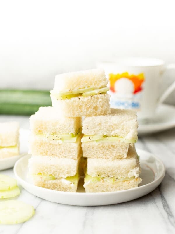 a plate with stacked cucumber sandwiches
