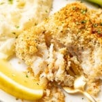 a plate with parmesan crusted cod, mashed potatoes, green beans, and a fork